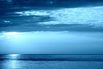 Obraz premium Sunrise over the sea near the coast of Sicily, Italy. Natural bakground blue color toned