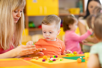 Group of children on art classes with teachers in kindergarten