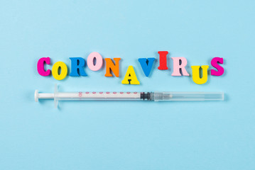Word Coronavirus written on blue background.  Top view.