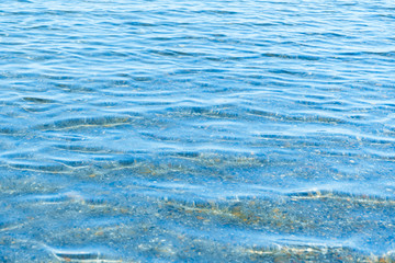 Sea blue water surface with waves near the shore. Background texture.