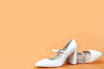 White high heel women's shoes on a orange background. Side view, close up. Stylish trendy shoes for the spring and summer season. Feminine fashion concept. Legendary Mary Jane Shoes. Copy space