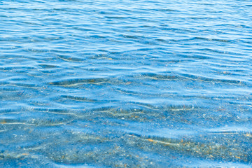 Sea blue water surface with waves near the shore. Background texture.