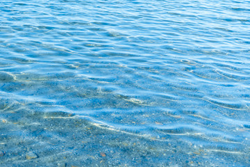 Sea blue water surface with waves near the shore. Background texture.