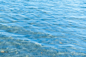 Sea blue water surface with waves near the shore. Background texture.
