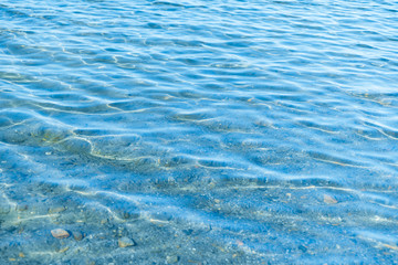 Sea blue water surface with waves near the shore. Background texture.
