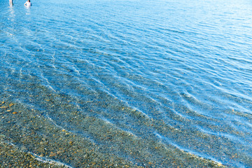 Sea blue water surface with waves near the shore. Background texture.
