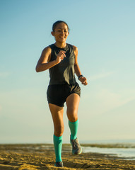 outdoors fitness portrait of young attractive and happy Asian Indonesian woman in compression socks...
