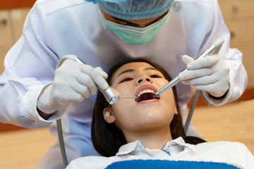 Fototapeta premium The Doctor is holding the tools for the patient.Dentist examined the patient's teeth at the clinic.Dentists perform dental floss and oral hygiene for patients at the clinic.