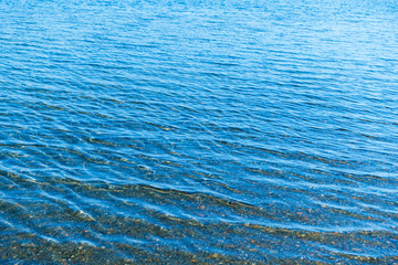 Obraz premium Sea blue water surface with waves near the shore. Background texture.