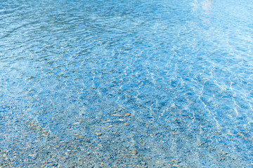 Sea blue water surface with waves near the shore. Background texture.