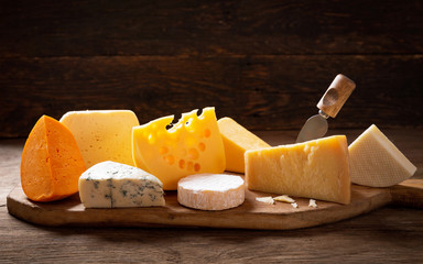 various types of cheese on a wooden background