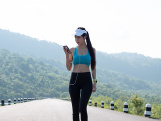 Naklejka premium Young asian woman body slim fit fitness sexy in sportwear running on road while listening to the music. In hand smart phone with earphones. Sportswoman, Health lifestyle Concept.