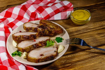 Baked pork belly in a plate on wooden table