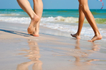 Walking on the sand. Legs the sea. The seaside resort.