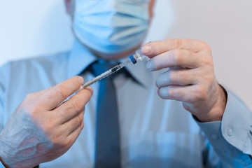 Coronavirus quarantine and Air pollution pm2.5 concept. Old sick man wearing respirator mask for protect holds syringe and medicine for injection. Wuhan, China epidemic virus symptoms background.