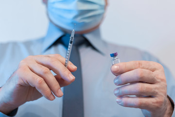 Coronavirus quarantine and Air pollution pm2.5 concept. Old sick man wearing respirator mask for protect holds syringe and medicine for injection. Wuhan, China epidemic virus symptoms background.