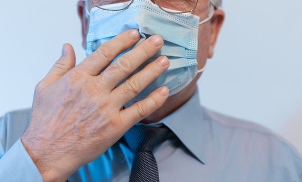 Coronavirus quarantine and Air pollution pm2.5 concept. Old sick man wearing respirator mask for protect holds hands near the face. Wuhan, China epidemic virus symptoms background.