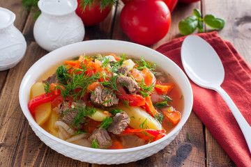 Khashlama with beef and vegetables on a wooden table, selective focus