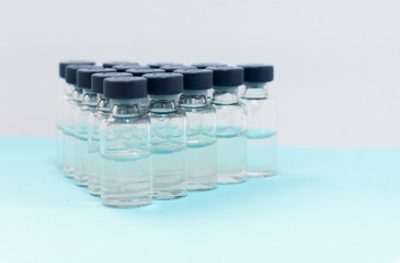 Medicine in vials, ready for vaccine injection on blue background. Cancer, painand diabetes treatment, pharmaceutical medicine concept .