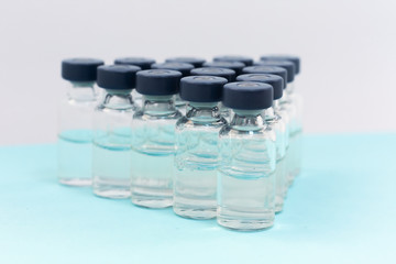 Medicine in vials, ready for vaccine injection on blue background. Cancer, painand diabetes treatment, pharmaceutical medicine concept .