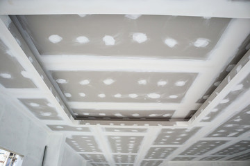 ceiling gypsum board installation at construction site - obrazy, fototapety, plakaty