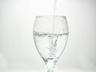 Pour water into the glass until small bubbles of various shapes are formed. White background