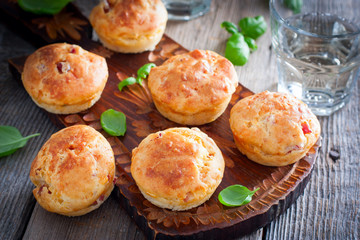 Muffins with ham and cheese on a wooden board, selective focus