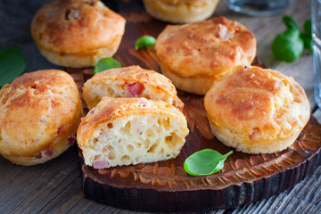 Muffins with ham and cheese on a wooden board, selective focus