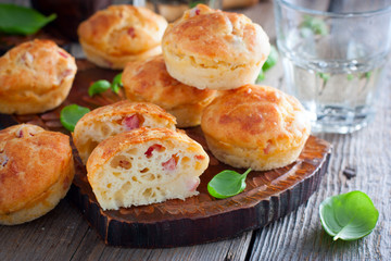 Muffins with ham and cheese on a wooden board, selective focus
