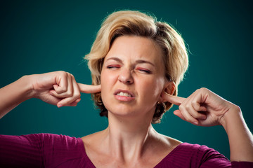 Obraz premium A portrait of woman closing her ears. People,lifestyle and emotions concept
