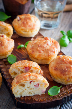 Muffins with ham and cheese on a wooden board, selective focus