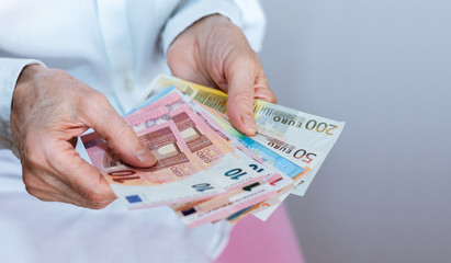 Female woman hand holds out a pack of euro close up, finance business concept.