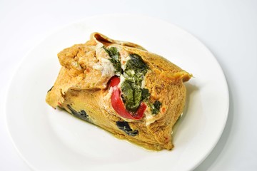 Thai Steamed Curried Fish in banana leaf placed on a white dish.