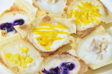 khanom khrok,Thailand desserts  made from coconut milk, filled with a lilac pumpkin in a white plate.