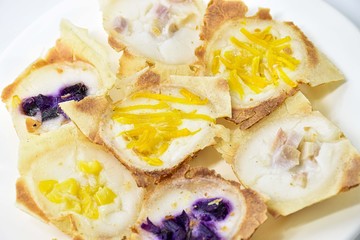 khanom khrok,Thailand desserts  made from coconut milk, filled with a lilac pumpkin in a white plate.