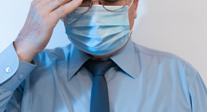 Coronavirus quarantine and Air pollution pm2.5 concept. Old sick man wearing respirator mask for protect holds hands near the face. Wuhan, China epidemic virus symptoms background.