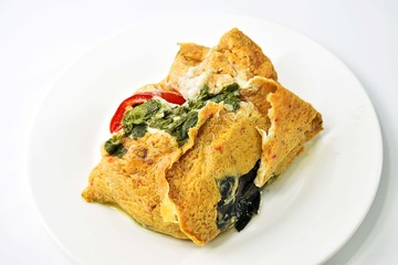 Thai Steamed Curried Fish in banana leaf placed on a white dish.