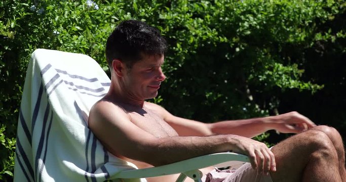 Handsome man sunbathing outside. Person tanning outdoors