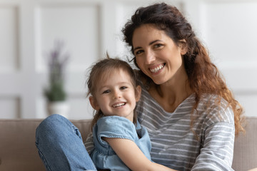 Little preschool kid girl embracing smiling mommy.