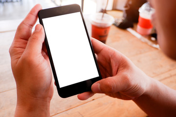 Mockup picture of business man’s hands holding smart phone with white blank screen in modern place.