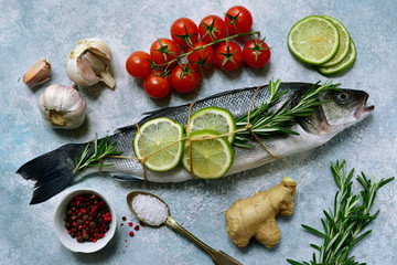 Fresh raw sea bass with ingredients for making. Top view with copy space.