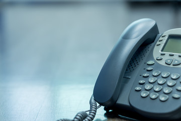 Close Up keypad number  analog phone is placed on a wooden floor in the office.