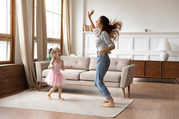 Crazy energetic family of two dancing in living room.