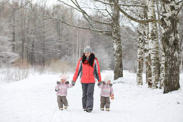 Fototapeta na wymiar Children walk in the park in winter. Winter forest a family with children on a walk. A cold winter day is a family walk.