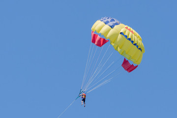 Parasailing on blue sky background. Parachute in the sky