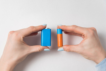 Women hands holding generic AA and PP3 batteries. Accumulator on white background.