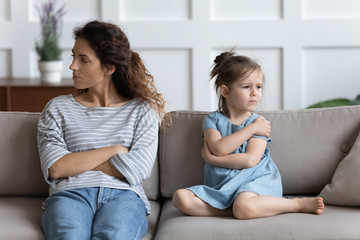 Obraz premium Stressed young mother ignoring offended little preschool daughter.