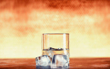 A glass of hard alcohol with ice on a bar counter. Whiskey with soda in a glass. Advertising alcoholic drink.