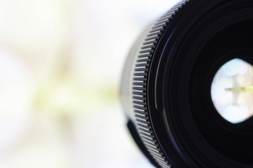 Equipment videographer and photographer. Lenses on the table against the background of bright lamps. Glare and bokeh in reflection of camera glass.