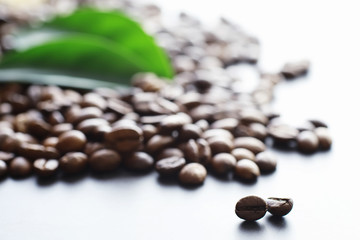 Bag of coffee. Coffee beans roasted on the table. Coffee beans with green leaves for cooking.